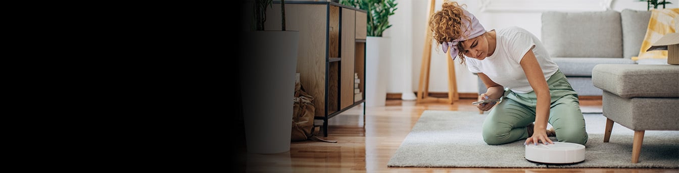Kvinne i stue med robotstøvsuger