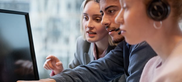 2 damer og en mann ser på pc skjerm