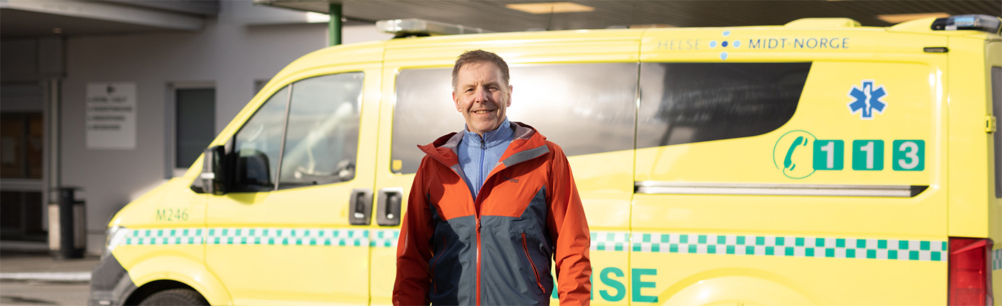 Trond Lauritsen i gründerbedriften PreAid, foran en ambulanse. 
