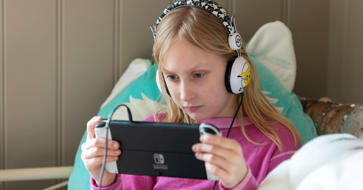 Ingrid, 8 år, gamer på jenterommet med headphones og Nintendo Switch