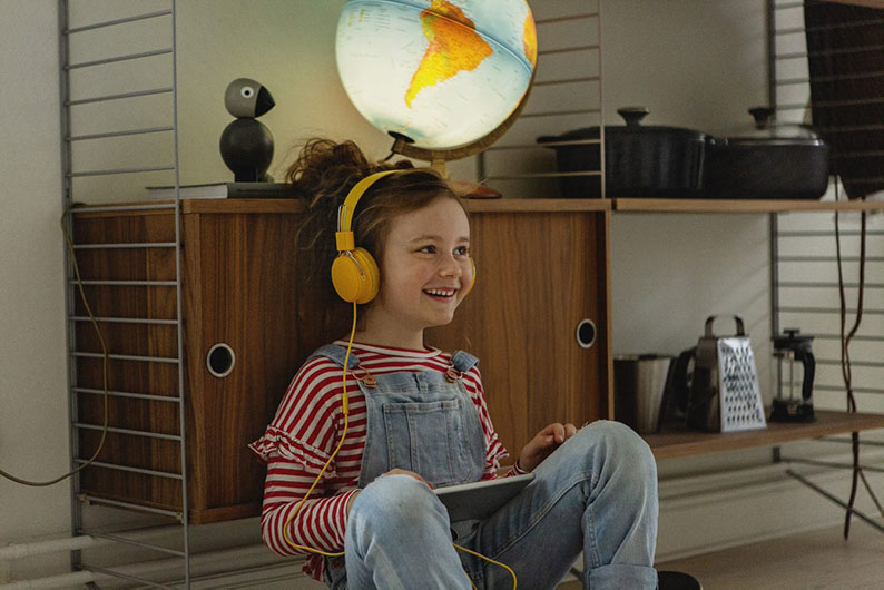 Et barn sitter med headset på