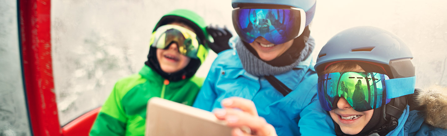 Familie sitter i skiheis og tar en selfie