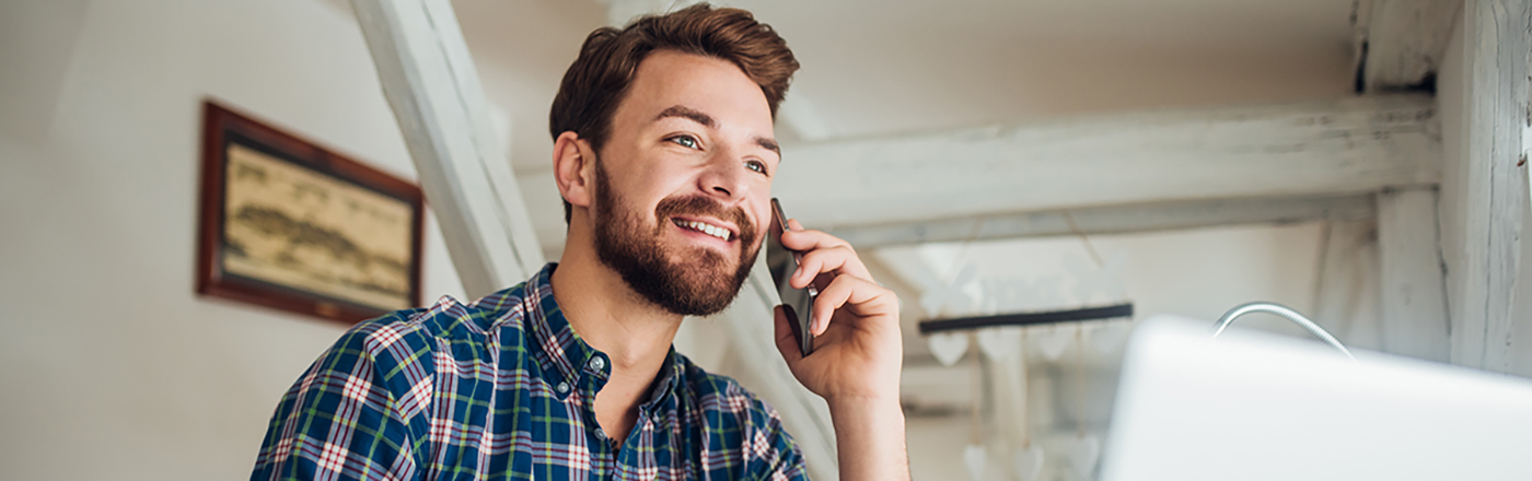 Mann som snakker i telefonen hjemme