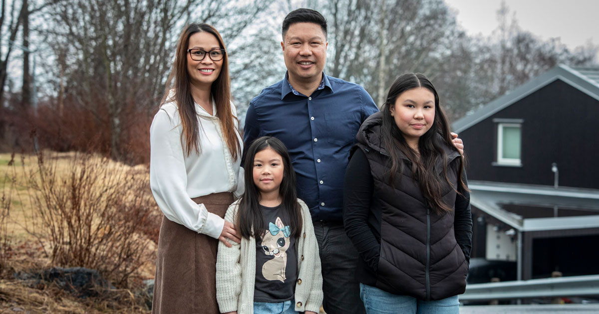 Familien smiler. Mor, far, to døtre.