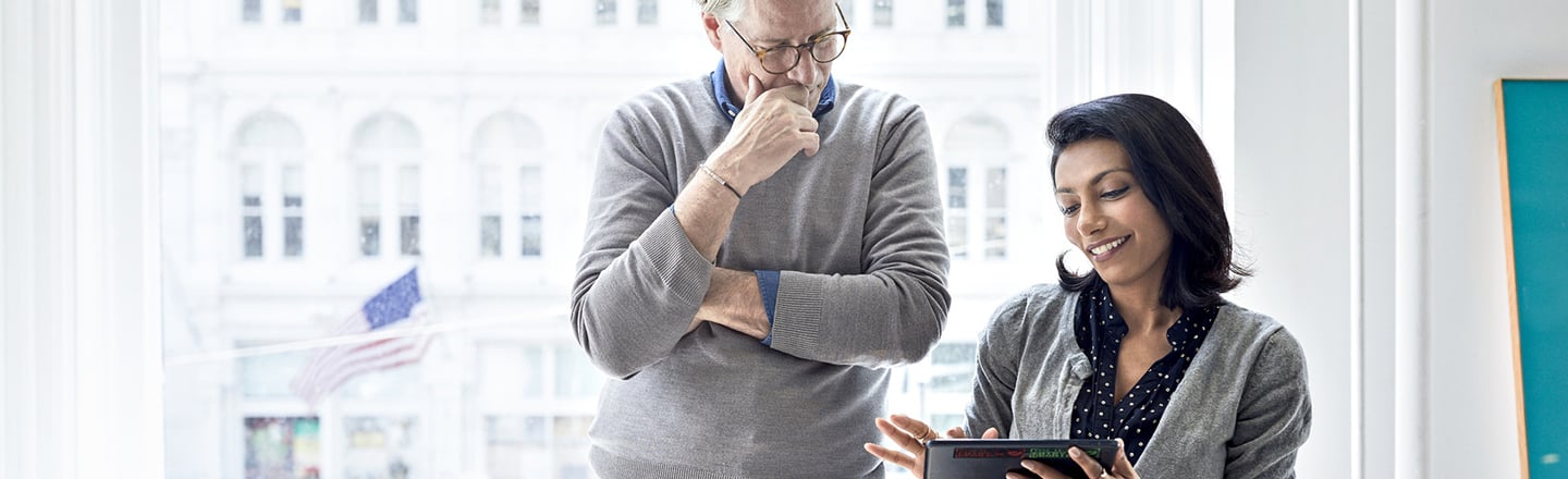 Mann og kvinne med mobiltelefon på kontor