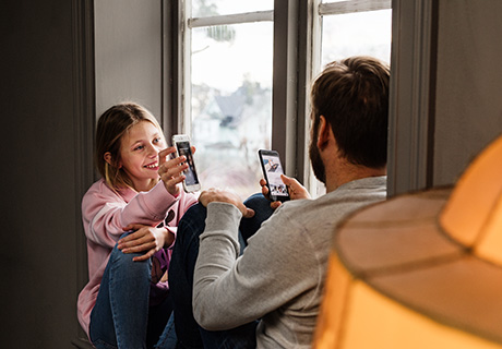Far og datter er på mobilen