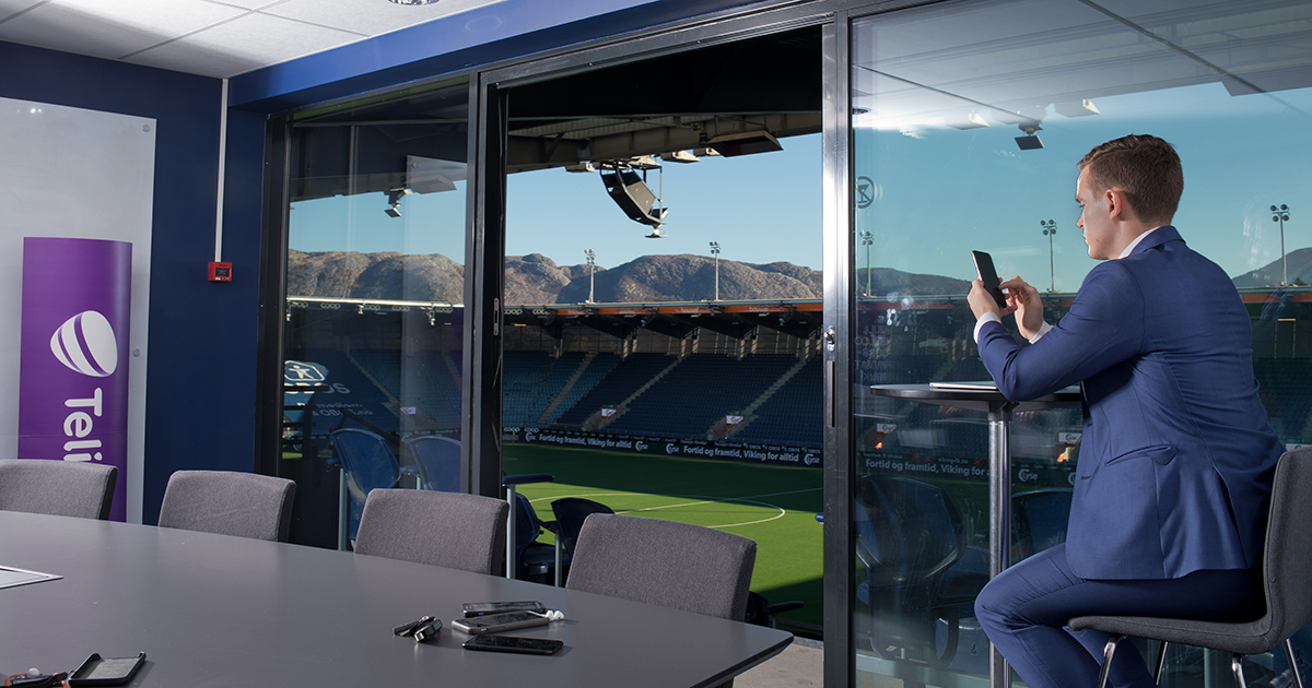 Mann bruker telefon i VIP-losje på SR-Bank Arena i Stavanger