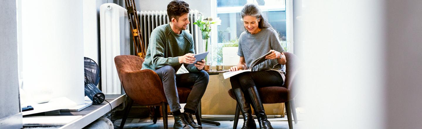 Å gå i partnerskap med en stor bedrift, kan være avgjørende for en startup. To personer diskuterer ved et bord.