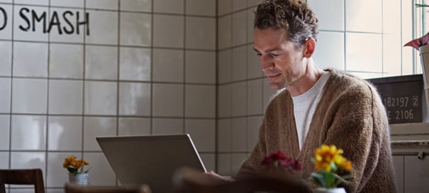 mann jobber på pc i en cafe