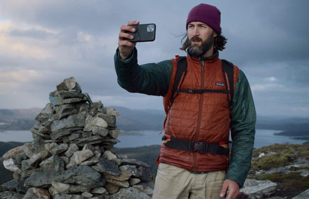 En er på fjelltur og tar selfie med mobilen 