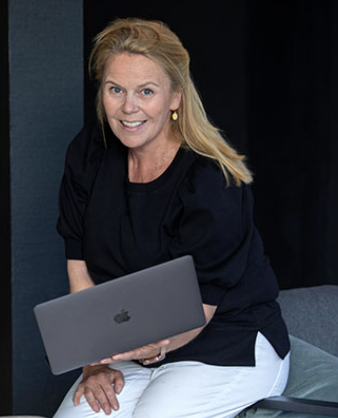 Bilde av Charlotte Heyerdahl i Telia, som holder en laptop på fanget.
