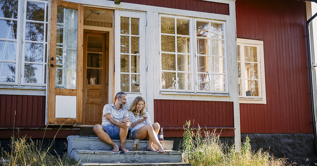 Par sitter med mobilen på hytta