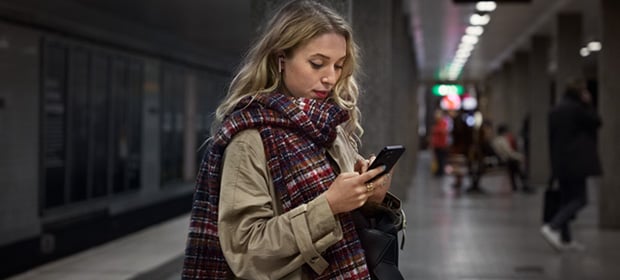 en dame holder en mobiltelefon