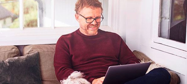 Mann med laptop og hund