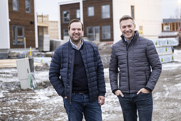 To menn smiler på byggeplass