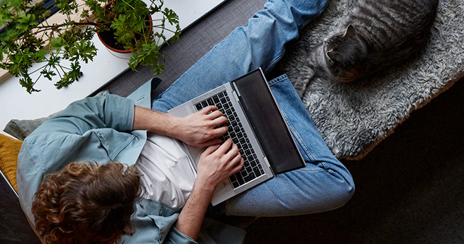 Dame sitter på hjemmekontor med laptop