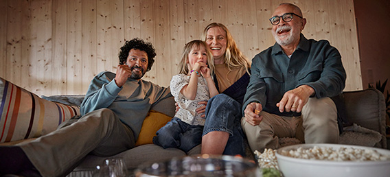Familie med popcorn foran TV-en.