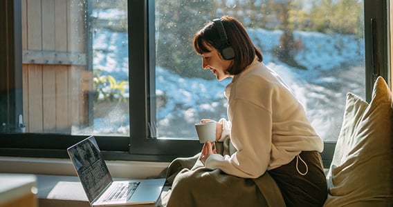 Kvinne med laptop ved bordet på hytta