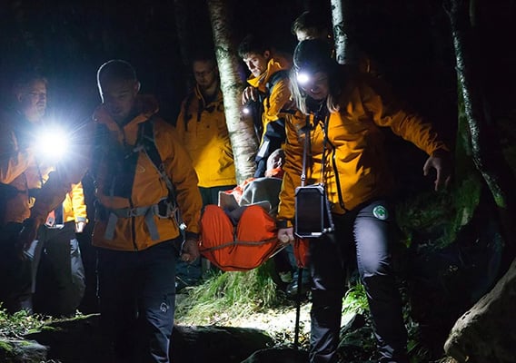 Redningsaksjon med Norsk Folkehjelp i skogen en mørk kveld