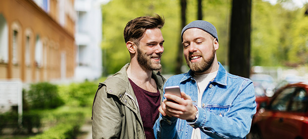 Par går på tur og ser på mobilen