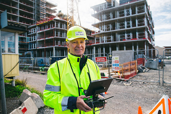 Arbeider styrer drone som inspiserer byggeplassen via 5G-nettet
