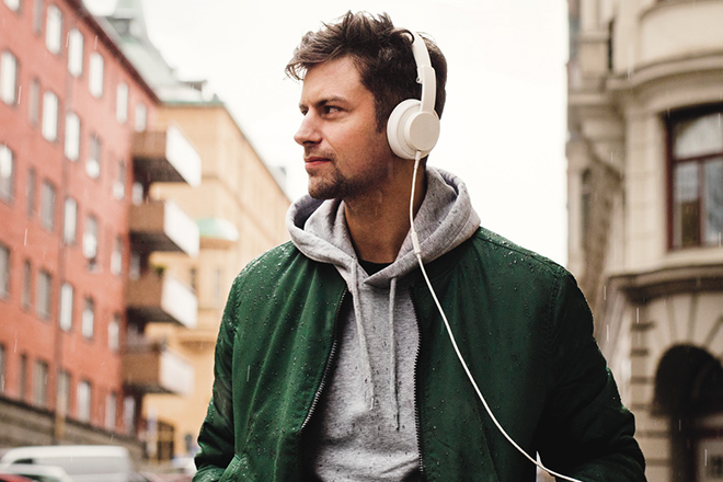 Ung mann hører musikk på hodetelefoner med Music Freedom